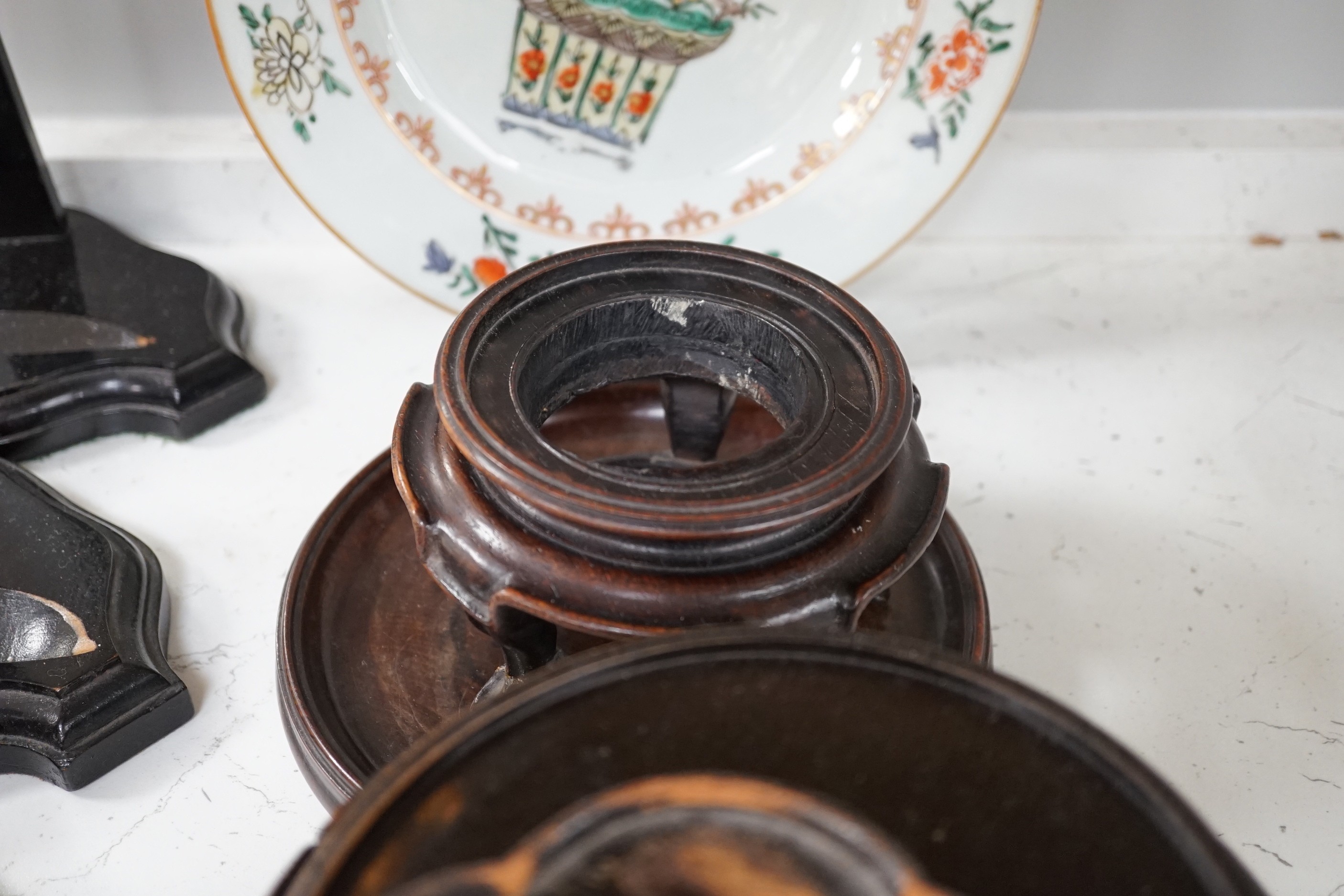 An 18th century Chinese export famille verte plate, Kangxi period Japanese carved wood stand and other various Chinese wood stands